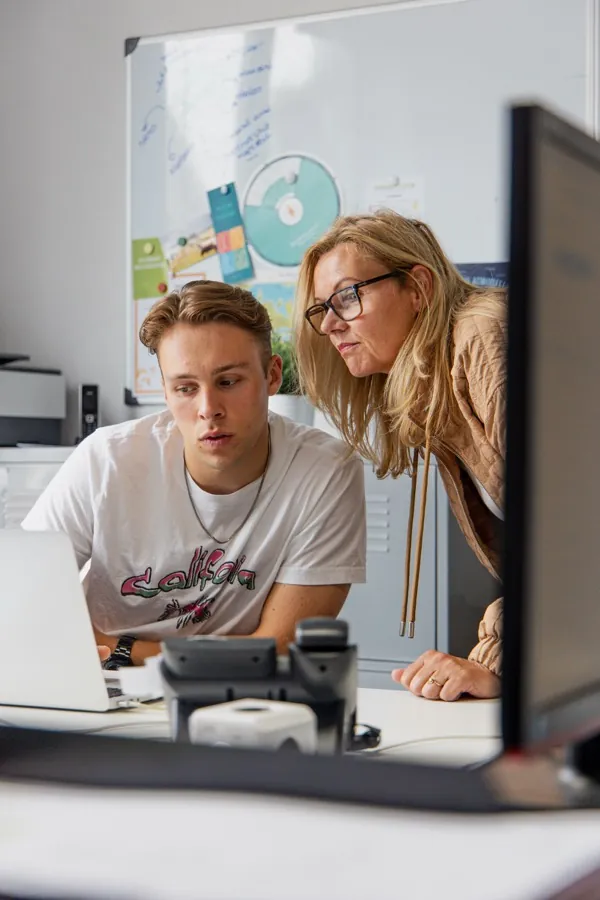 Coach kijkt mee op de werkplek